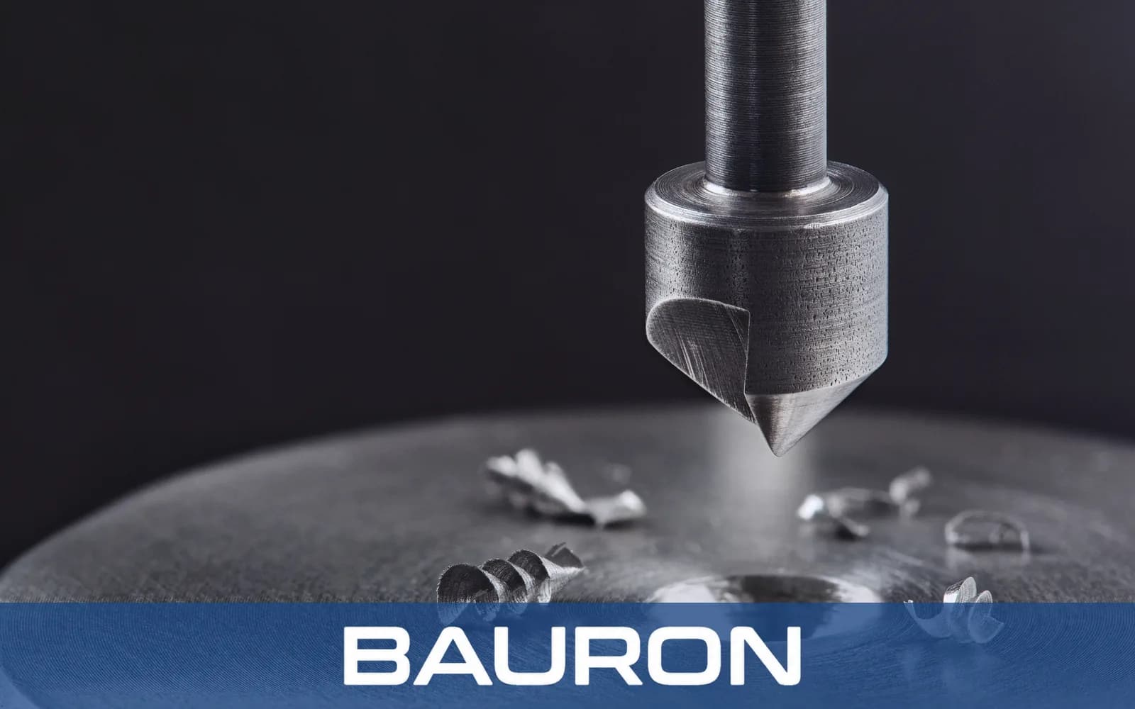 Countersink cutting a chamfer into a metal part with chips