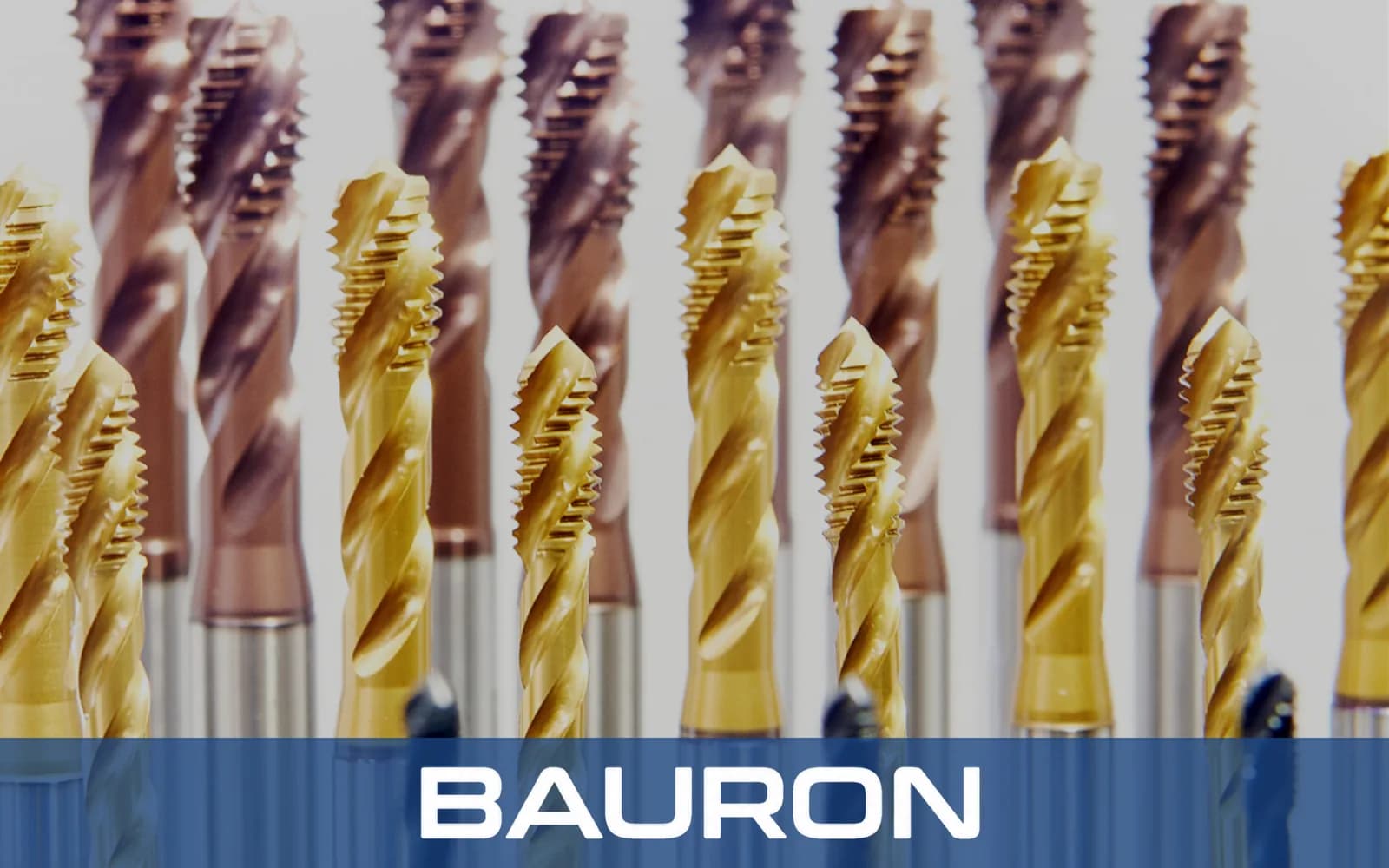 Rows of gold and bronze coated spiral flute taps